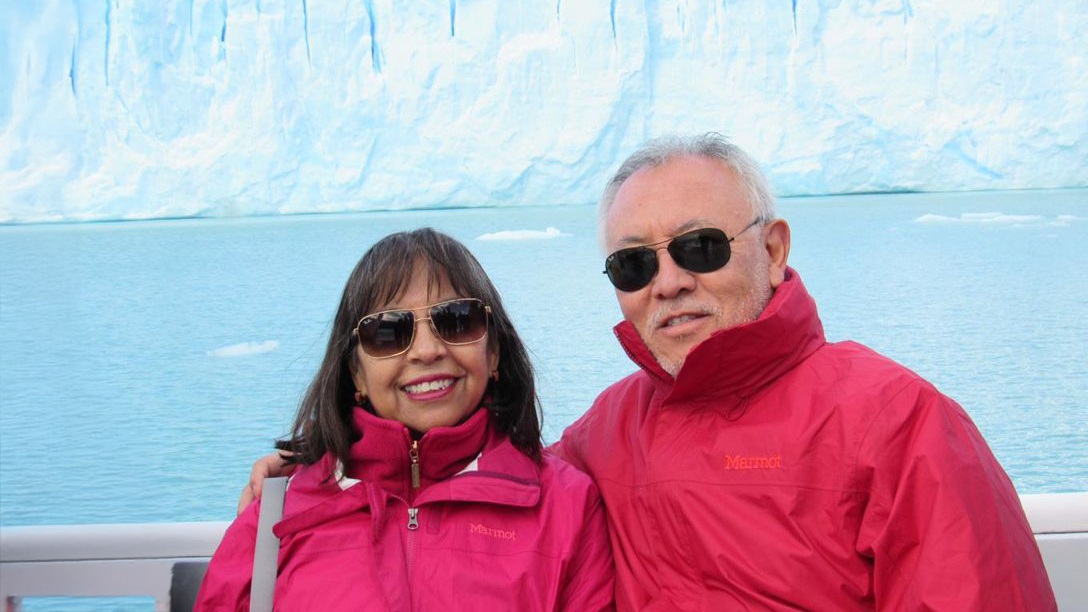 Nancy and her husband on a boat trip in front of glaciers.