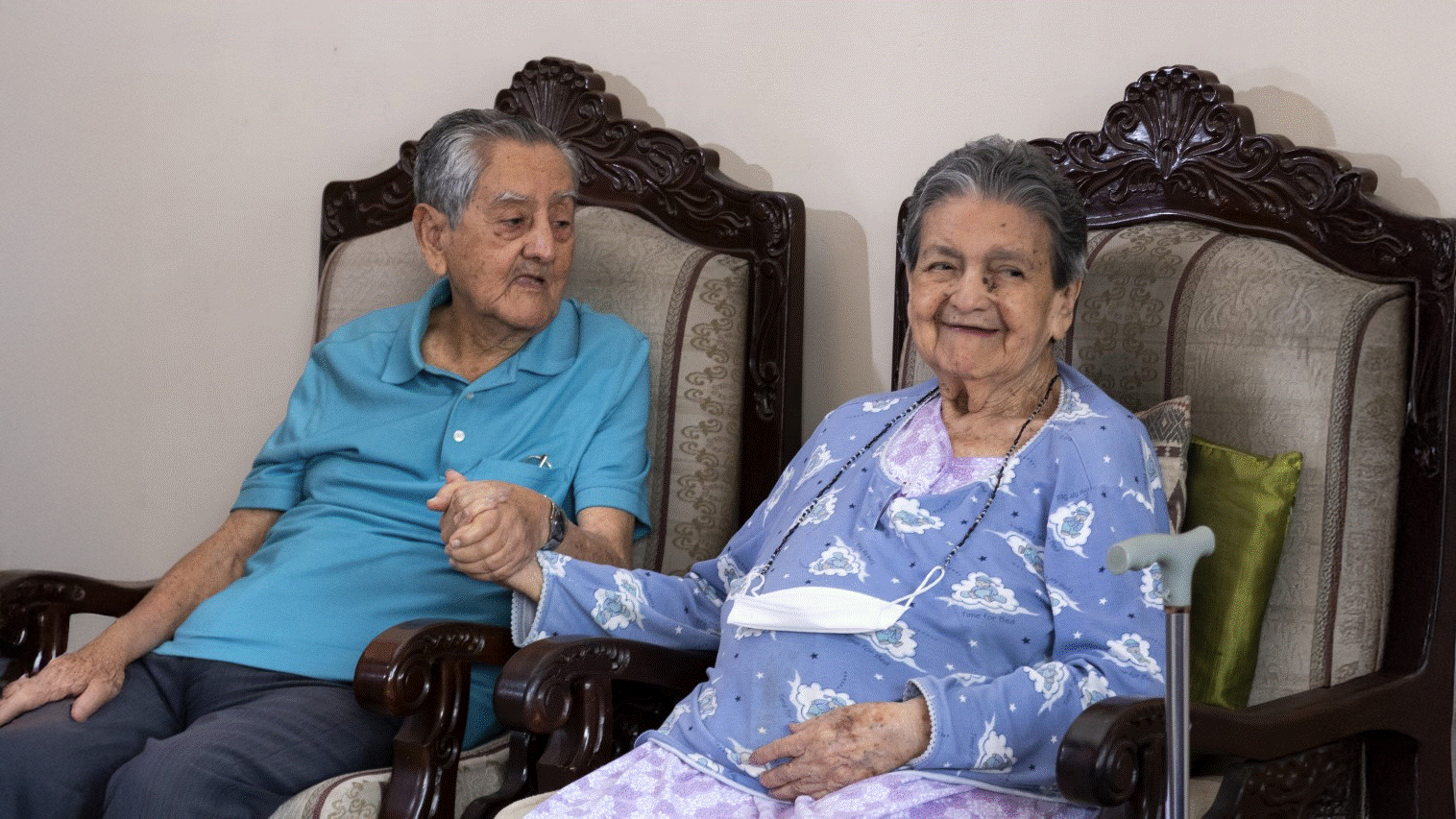 Jorge sitting next to his wife, holding hands.